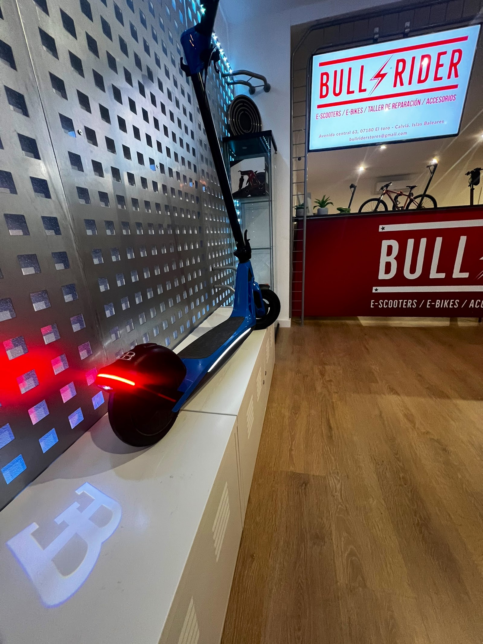 Patinete eléctrico con iluminación LED junto al mostrador de accesorios