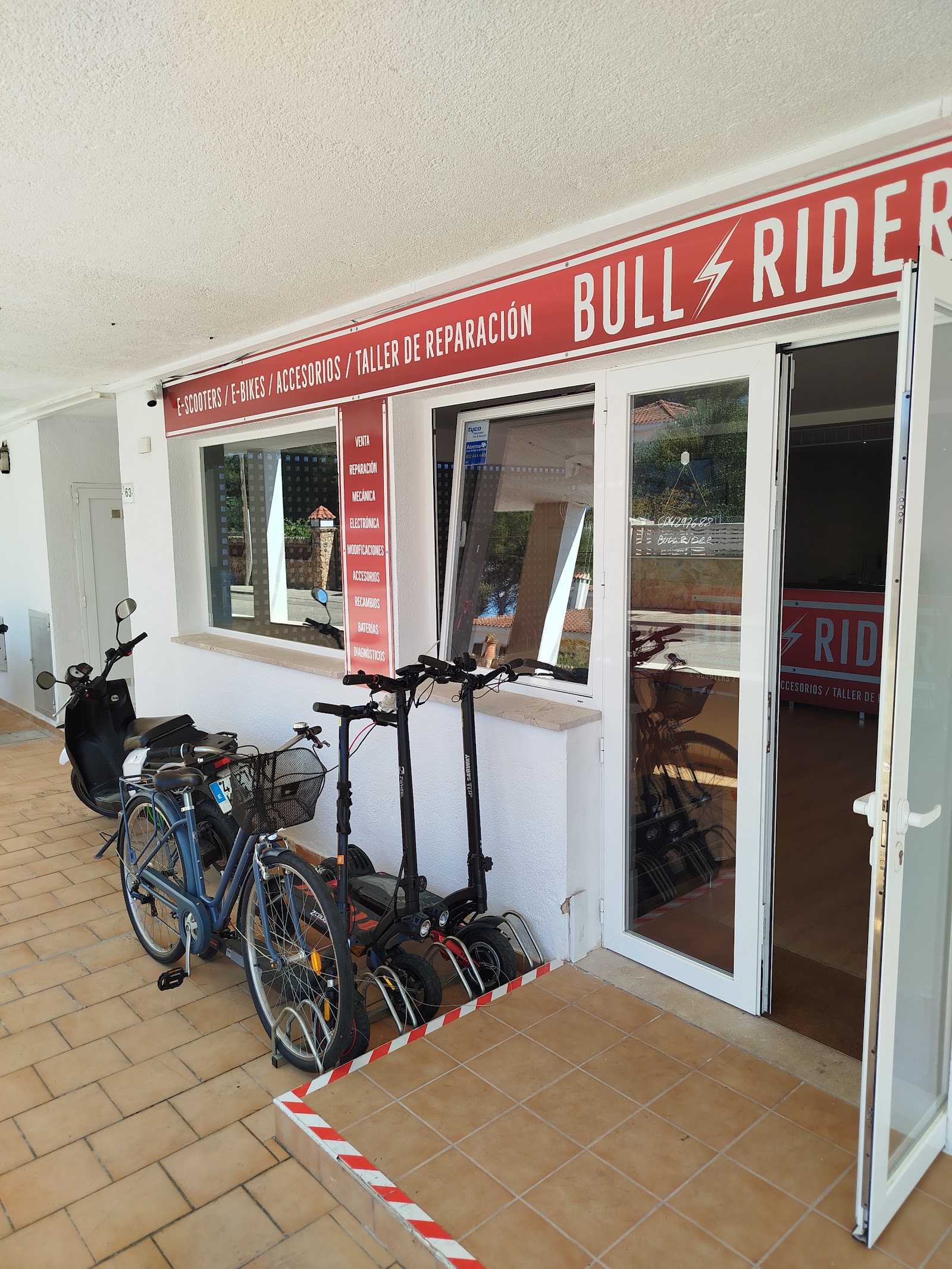 Fachada de BULLRIDER en la Av. Central de El Toro, con patinetes y bicicletas en la puerta